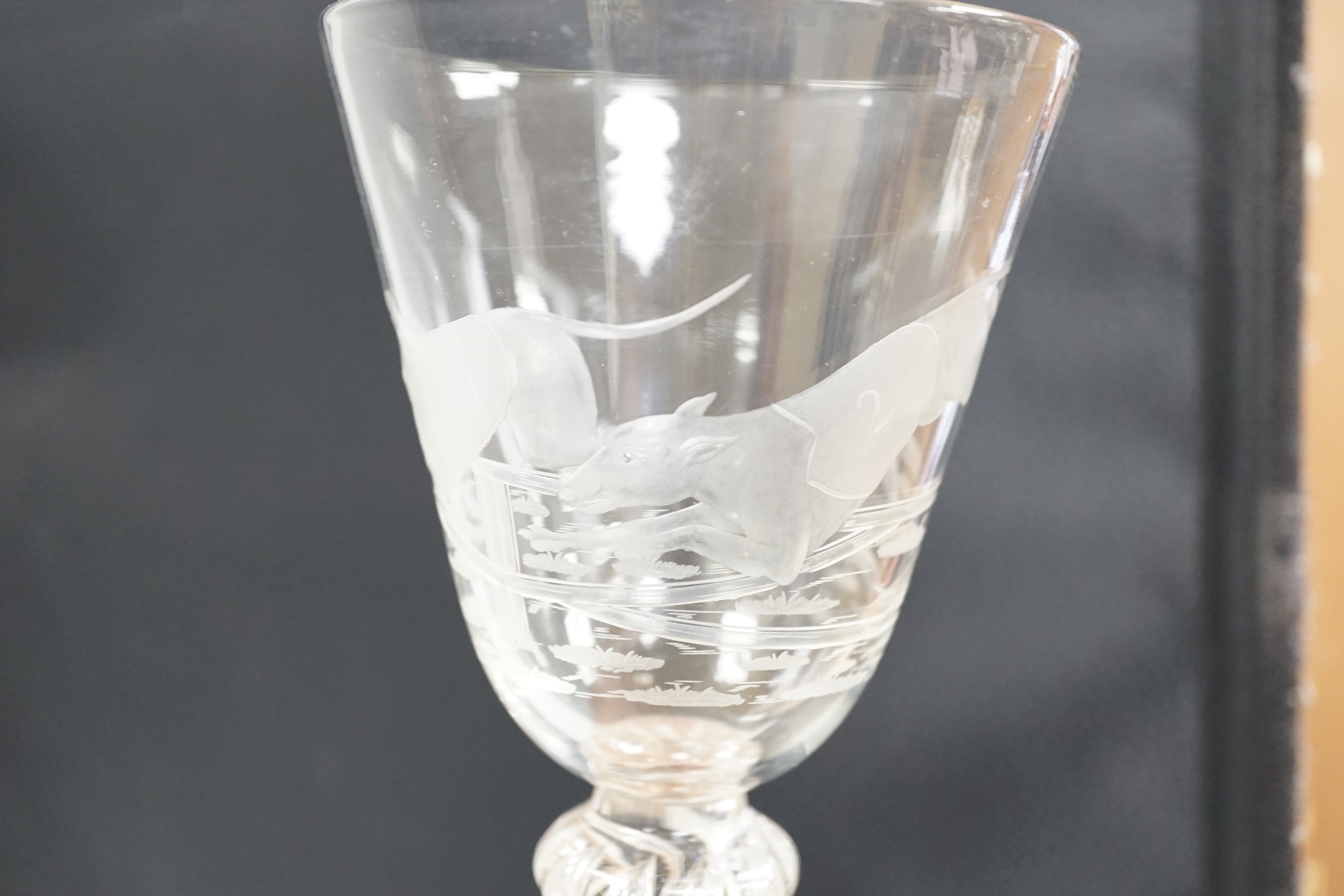 An English lead crystal mammoth trophy goblet, 19th century / early 20th century, engraved with two racing greyhounds, coats numbered 1 and 2, leaping a hurdle, four knopped multiple teared stem and a wide foot with brok